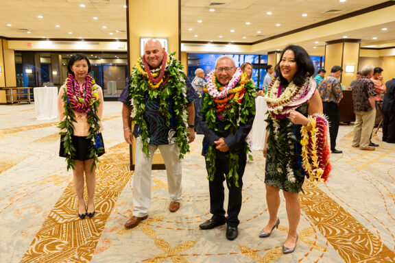 Honorees with leis stacked at an almost impossible height around their necks.
